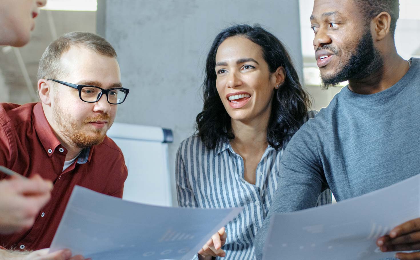 Four co-workers discussing charts